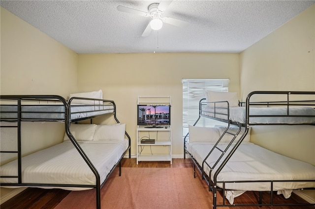 bedroom with hardwood / wood-style floors, ceiling fan, and a textured ceiling