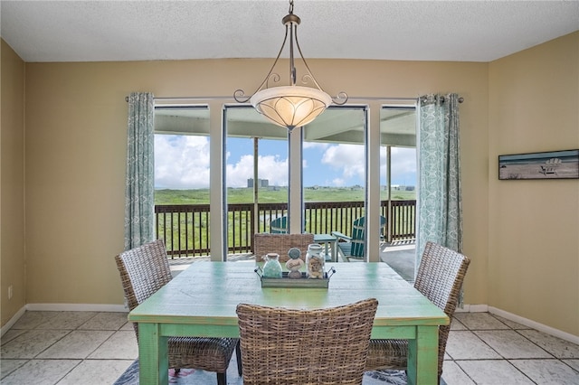 tiled dining space featuring a wealth of natural light and a textured ceiling