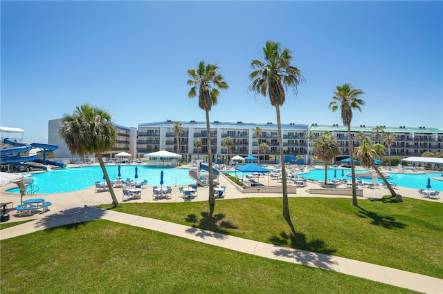 view of swimming pool with a lawn and a water slide