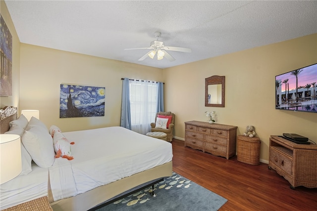 bedroom with ceiling fan, a textured ceiling, and dark hardwood / wood-style flooring