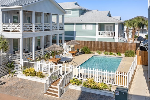 view of swimming pool featuring a sunroom and a patio