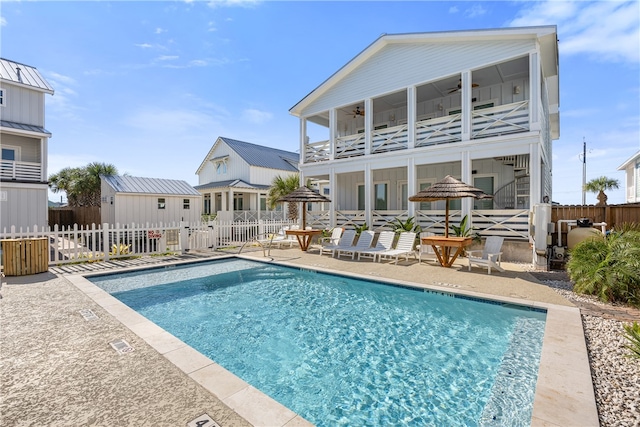 rear view of house featuring a patio, a balcony, ceiling fan, and a community pool