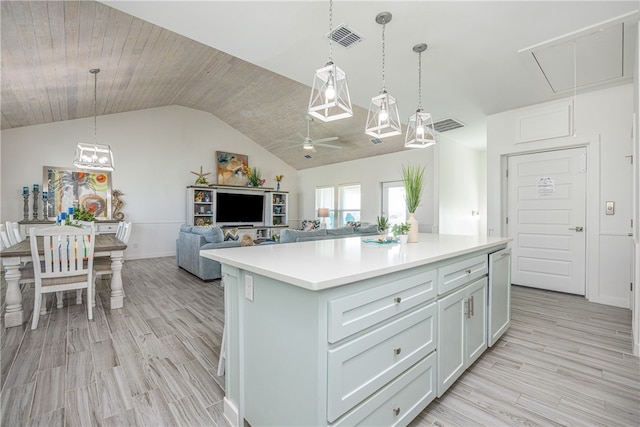 kitchen featuring vaulted ceiling, ceiling fan, pendant lighting, light hardwood / wood-style flooring, and a kitchen island