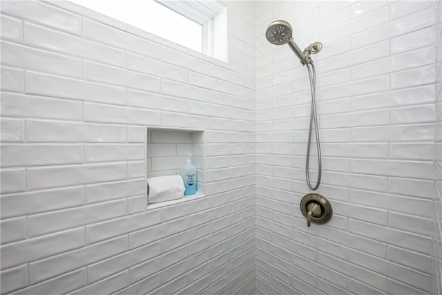 interior details featuring a tile shower