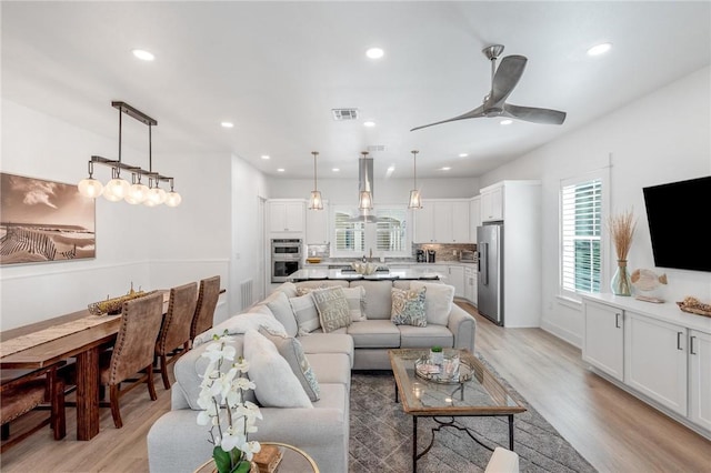 living area featuring light wood-style floors, recessed lighting, visible vents, and ceiling fan