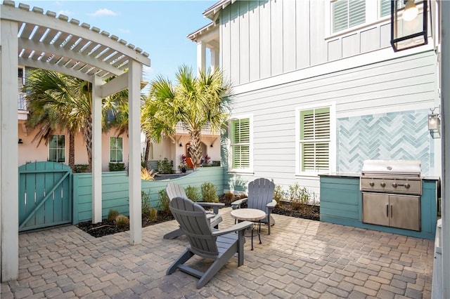 view of patio featuring an outdoor fire pit, a grill, an outdoor kitchen, and a pergola