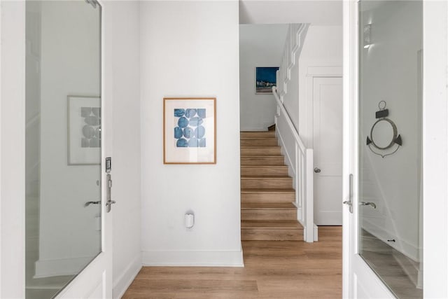 stairs featuring wood finished floors and baseboards