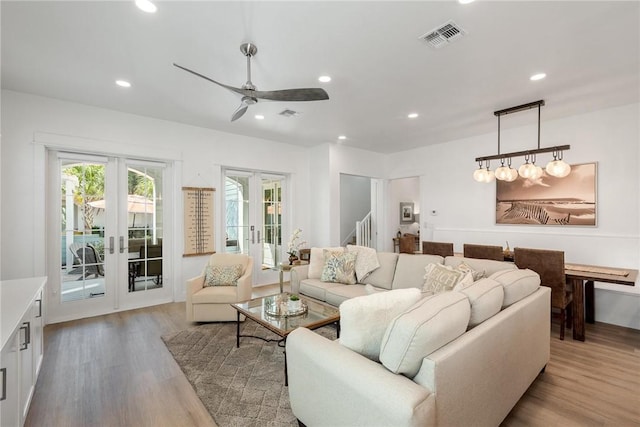 living room with visible vents, stairway, french doors, light wood-type flooring, and recessed lighting