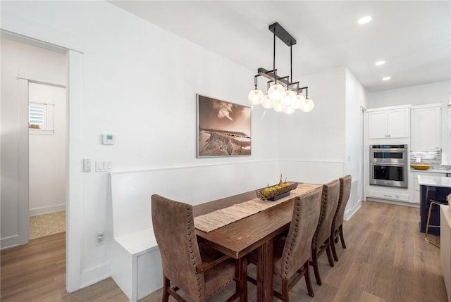 dining room featuring light wood-style flooring, baseboards, and recessed lighting