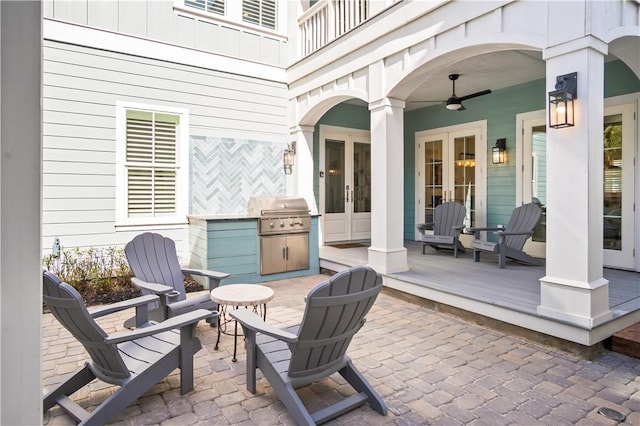 view of patio / terrace with an outdoor kitchen, grilling area, a ceiling fan, and french doors