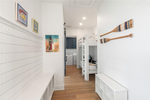 hall with attic access, visible vents, light wood-style flooring, washer and dryer, and recessed lighting