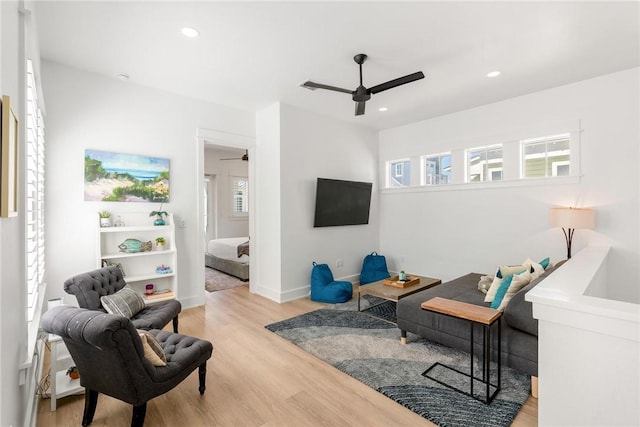 living area with baseboards, light wood-type flooring, a ceiling fan, and recessed lighting