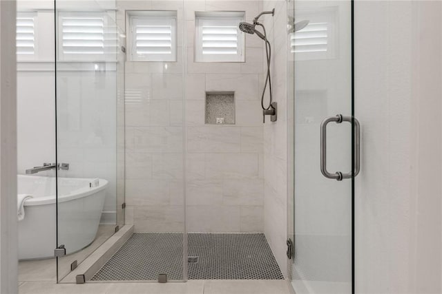 bathroom with a stall shower and a soaking tub