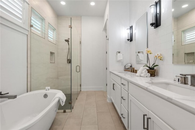 bathroom featuring a freestanding tub, a stall shower, a sink, and a wealth of natural light