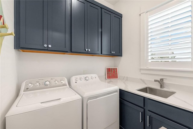 laundry room with independent washer and dryer, a sink, and cabinet space