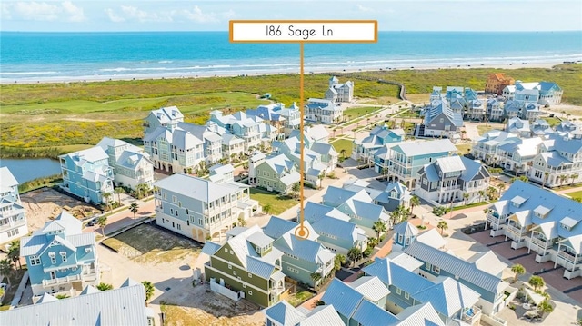 aerial view featuring a beach view, a water view, and a residential view