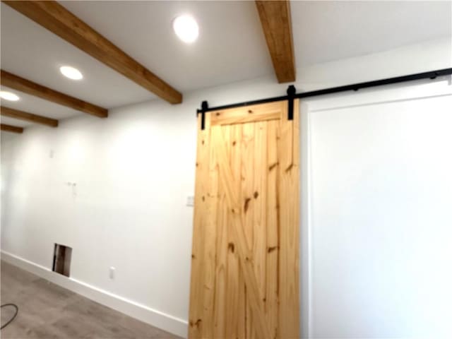 interior space featuring a barn door and beam ceiling