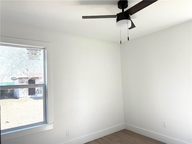 spare room with dark wood-type flooring and ceiling fan