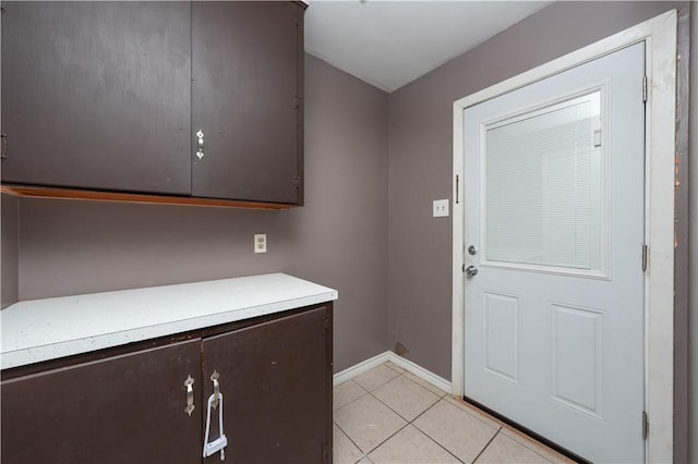 doorway to outside with light tile patterned floors and baseboards