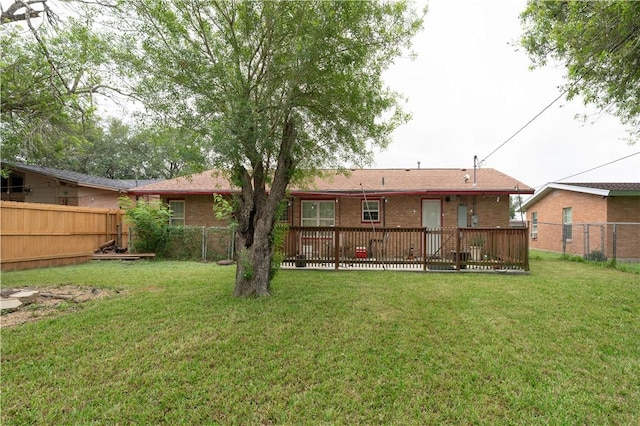 back of house featuring brick siding, a fenced backyard, and a yard