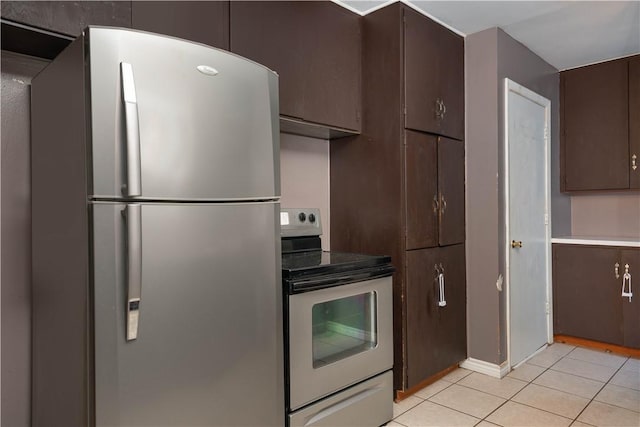 kitchen featuring light tile patterned floors, dark brown cabinets, and appliances with stainless steel finishes
