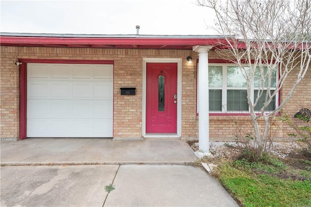 view of front facade with concrete driveway, an attached garage, and brick siding