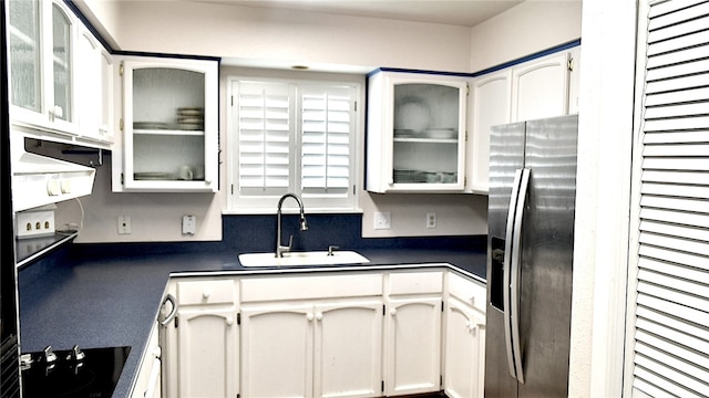 kitchen featuring white cabinetry, sink, black electric cooktop, and stainless steel fridge