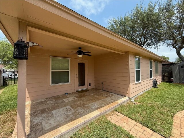 177 Whistlers Cv, Rockport, TX 78382 - view of exterior entry featuring ceiling fan, a patio, and a yard