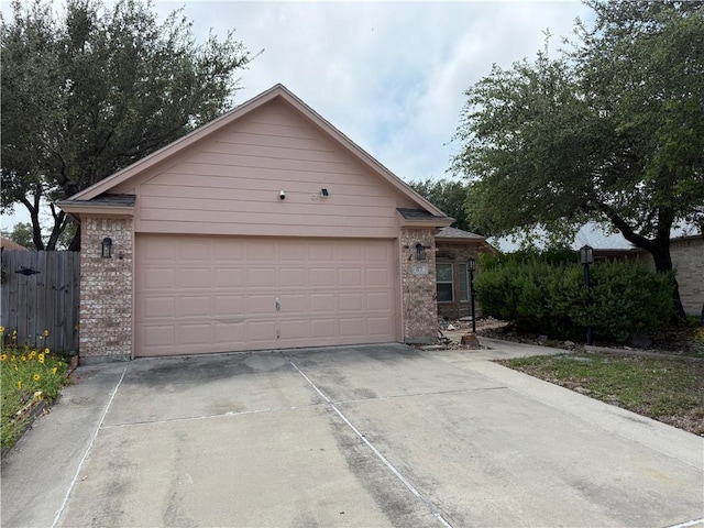 177 Whistlers Cv, Rockport, TX 78382 - view of front of house with brick siding, concrete driveway, fence, and an attached garage
