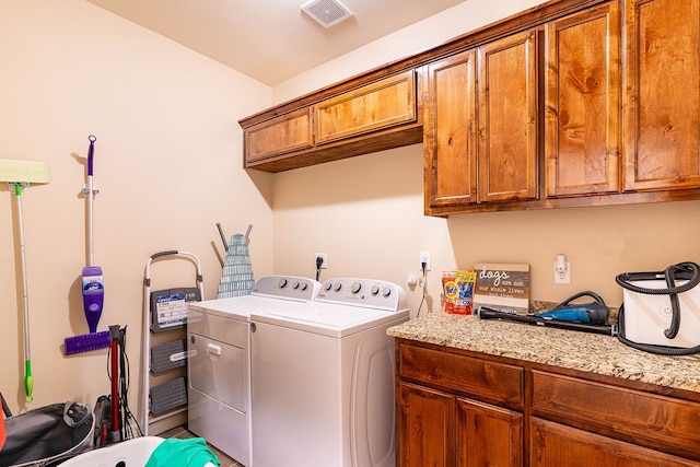 laundry area with washing machine and dryer and cabinets