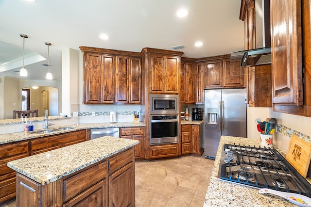 kitchen featuring light stone counters, hanging light fixtures, sink, tasteful backsplash, and appliances with stainless steel finishes