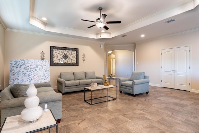 living room featuring ceiling fan, a raised ceiling, and crown molding