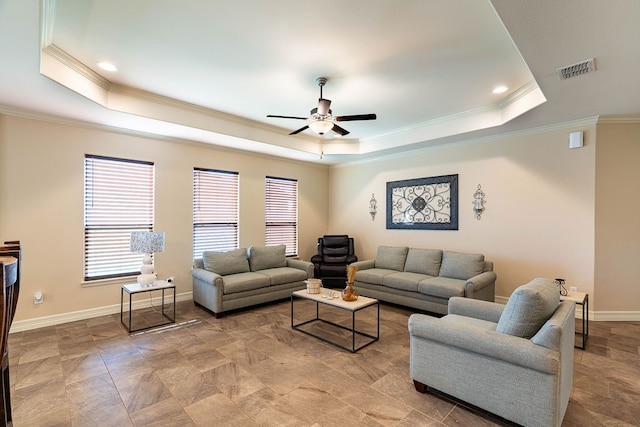 living room with ceiling fan, crown molding, and a tray ceiling