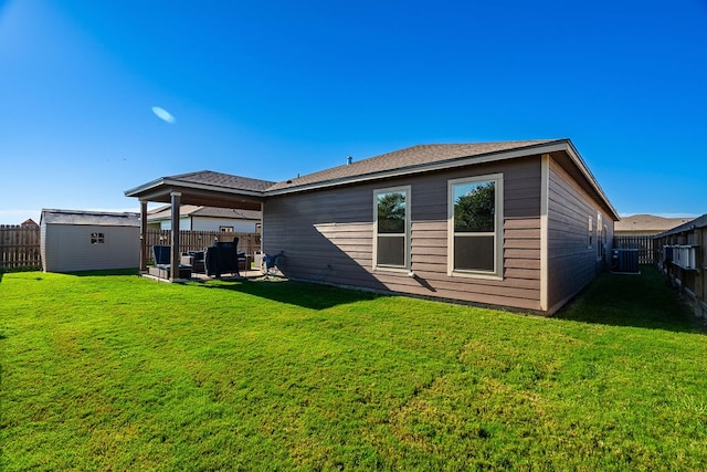 rear view of house with a shed, central air condition unit, a yard, and a patio area