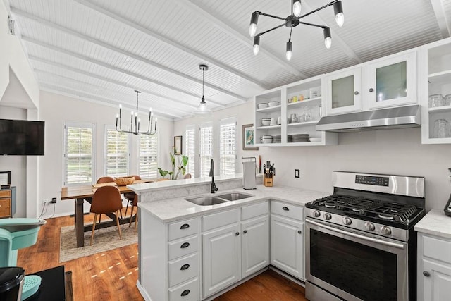 kitchen featuring kitchen peninsula, stainless steel gas range oven, hanging light fixtures, white cabinetry, and sink