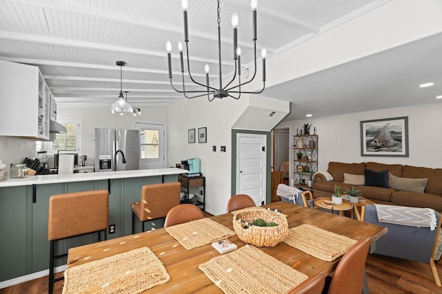 dining space featuring dark hardwood / wood-style flooring, an inviting chandelier, and beamed ceiling