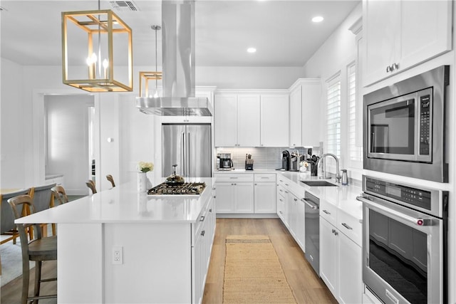 320 S Shore Dr, Port Aransas, TX 78373 - kitchen with stainless steel appliances, extractor fan, a kitchen island, light wood-style flooring, and a kitchen breakfast bar