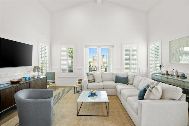 320 S Shore Dr, Port Aransas, TX 78373 - living area featuring high vaulted ceiling, wood finished floors, wainscoting, and a decorative wall