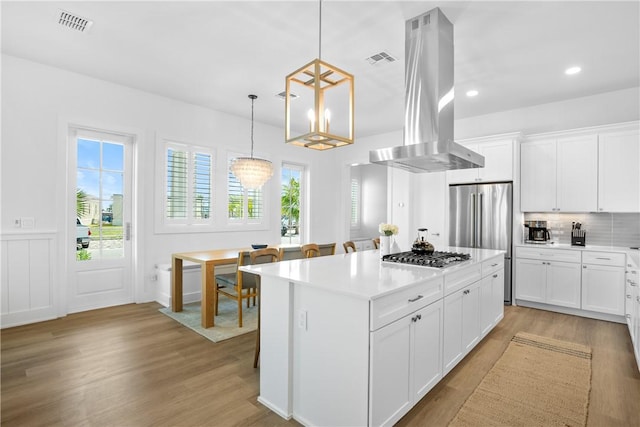 320 S Shore Dr, Port Aransas, TX 78373 - kitchen featuring island exhaust hood, stainless steel appliances, light wood finished floors, light countertops, and a center island