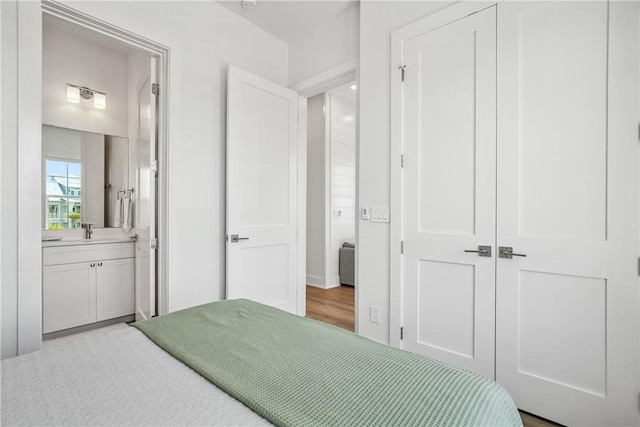 320 S Shore Dr, Port Aransas, TX 78373 - bedroom with connected bathroom and wood finished floors