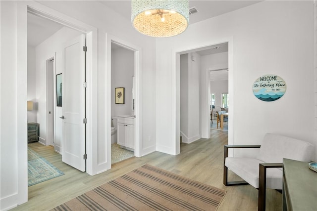 320 S Shore Dr, Port Aransas, TX 78373 - hallway with light wood-style floors and a chandelier