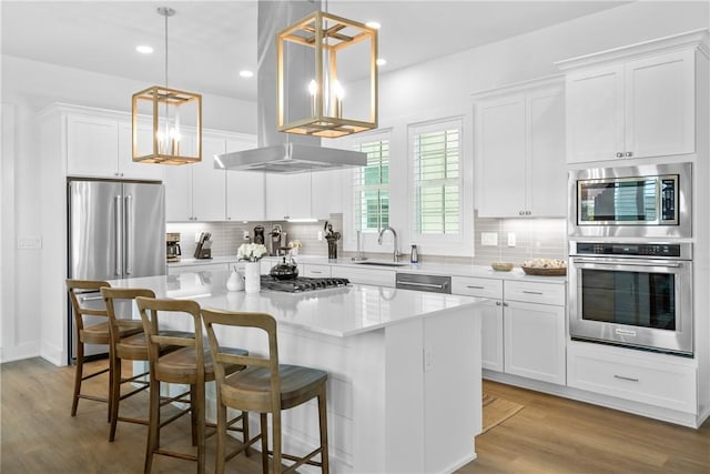 320 S Shore Dr, Port Aransas, TX 78373 - kitchen with appliances with stainless steel finishes, a center island, island range hood, decorative backsplash, and white cabinets