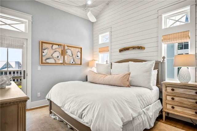 328 Coastline Dr, Port Aransas, TX 78373 - bedroom featuring high vaulted ceiling, multiple windows, wood finished floors, and wooden walls