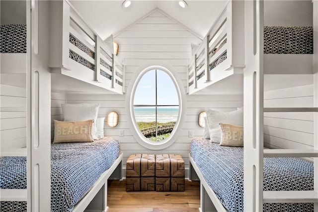 328 Coastline Dr, Port Aransas, TX 78373 - bedroom featuring wood finished floors, lofted ceiling, wood walls, recessed lighting, and a water view