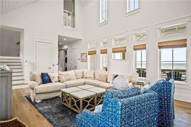 328 Coastline Dr, Port Aransas, TX 78373 - living area featuring hardwood / wood-style flooring, healthy amount of natural light, stairs, high vaulted ceiling, and a water view