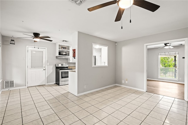 4249 Dody St, Corpus Christi, TX 78411 - kitchen with stainless steel electric range oven, ceiling fan, light tile patterned floors, light countertops, and white cabinetry