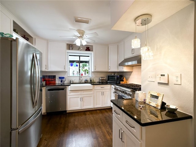 kitchen with under cabinet range hood, a sink, white cabinets, appliances with stainless steel finishes, and pendant lighting