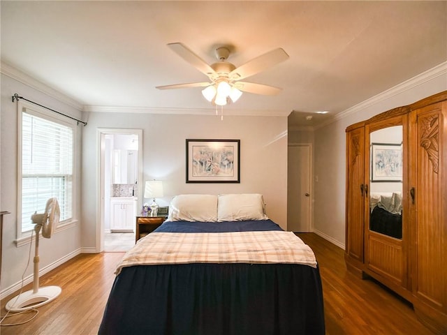 bedroom with ensuite bathroom, ornamental molding, a ceiling fan, wood finished floors, and baseboards