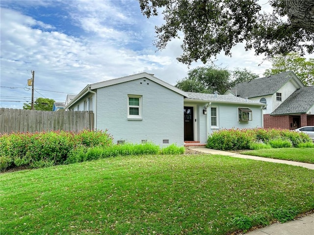 ranch-style home featuring a front yard, crawl space, brick siding, and fence