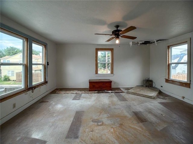 empty room with ceiling fan, baseboards, and light wood-style floors